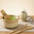 Set matcha japonais en céramique artisanale avec bol à matcha, fouet en bambou, cuillère chashaku, support à fouet et tamis en inox, présenté dans une ambiance zen et minimaliste.